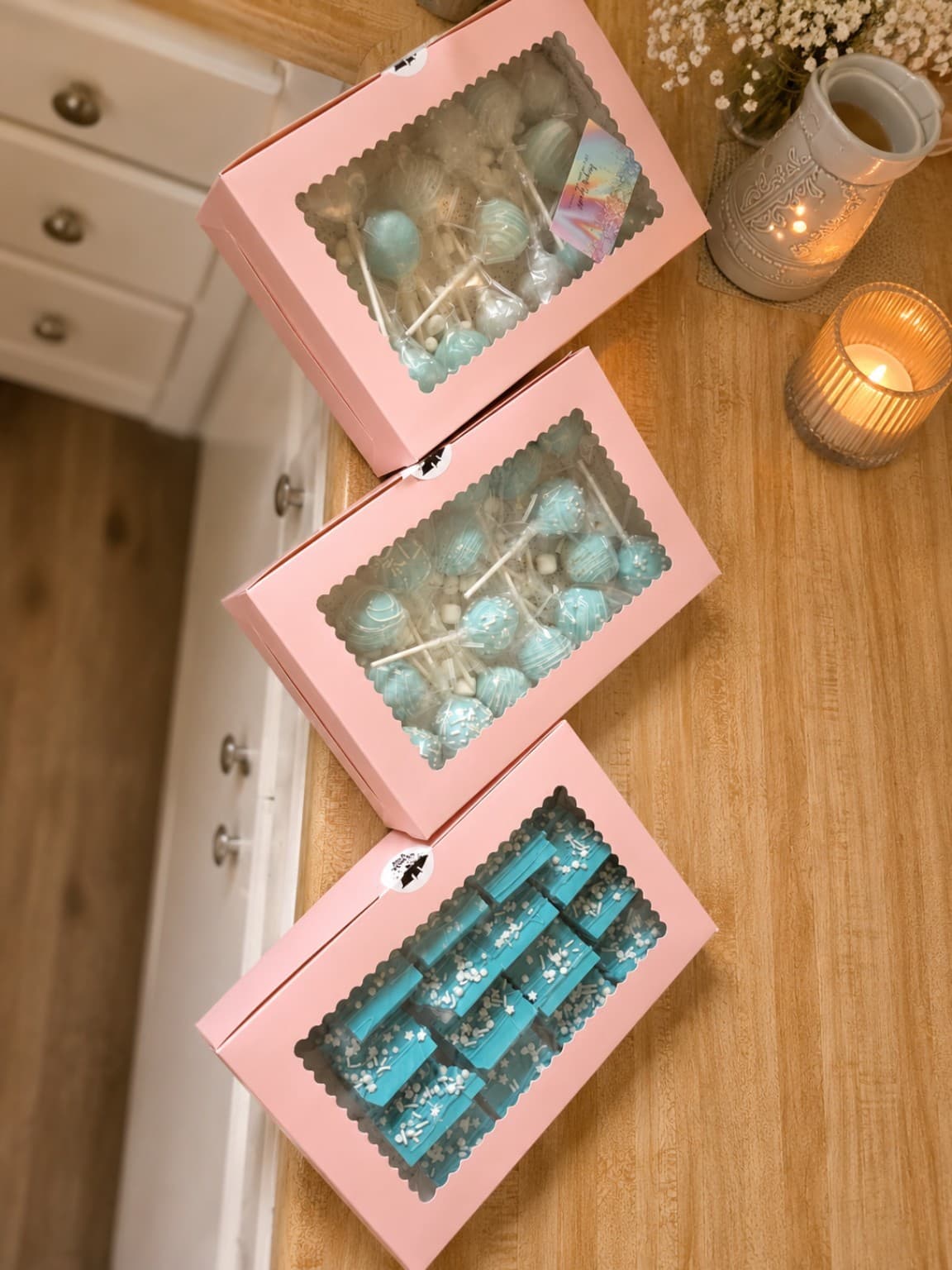 Three pink gift boxes filled with blue custom Sugar Spell treats
